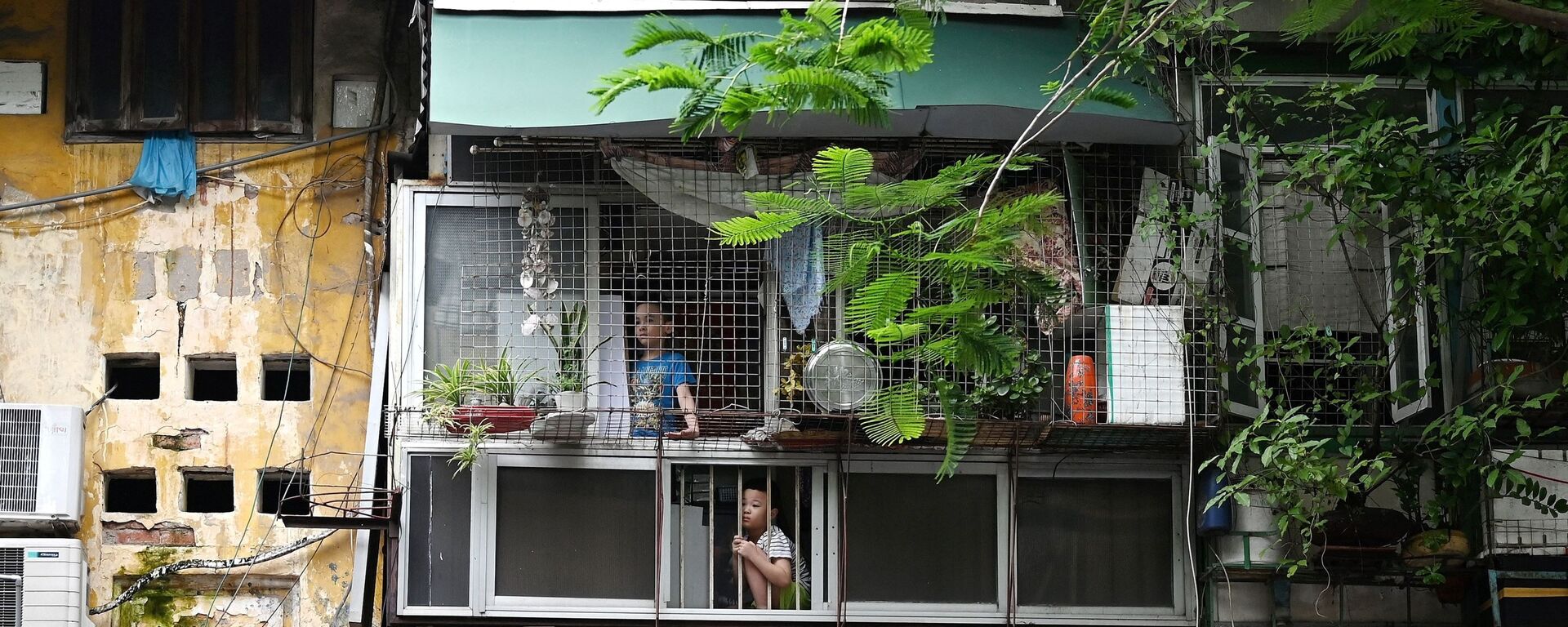 Trẻ em ở trong nhà nhìn ra phố vắng trong đợt cách ly xã hội ở Hà Nội, Việt Nam. - Sputnik Việt Nam, 1920, 30.09.2022