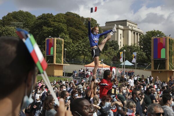 Cô gái cầm cờ Pháp khi thực hiện các bài tập nhào lộn trong khu vực dành cho người hâm mộ Thế vận hội Olympic tại Trocadero ở Paris - Sputnik Việt Nam