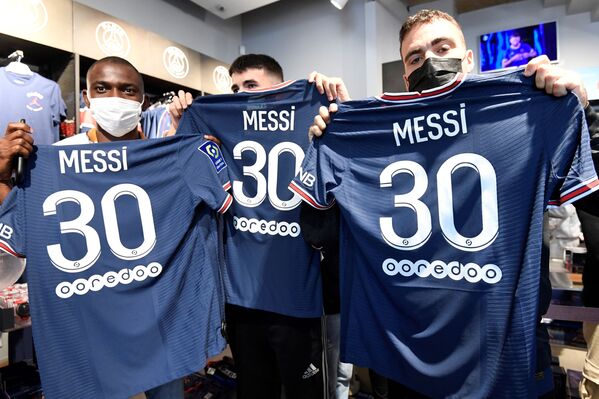 Người hâm mộ tạo dáng với áo phông manh hình cầu thủ bóng đá Argentina Lionel Messi của PSG ở Paris - Sputnik Việt Nam