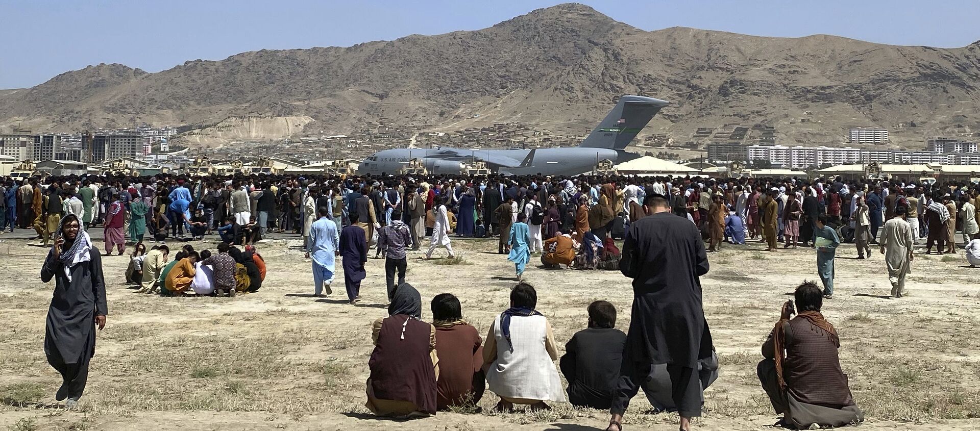 Hàng trăm người tập trung gần một chiếc máy bay vận tải C-17 của Không quân Hoa Kỳ ở vành đai sân bay quốc tế ở Kabul, Afghanistan, Thứ Hai, ngày 16 tháng 8 năm 2021 - Sputnik Việt Nam, 1920, 17.08.2021