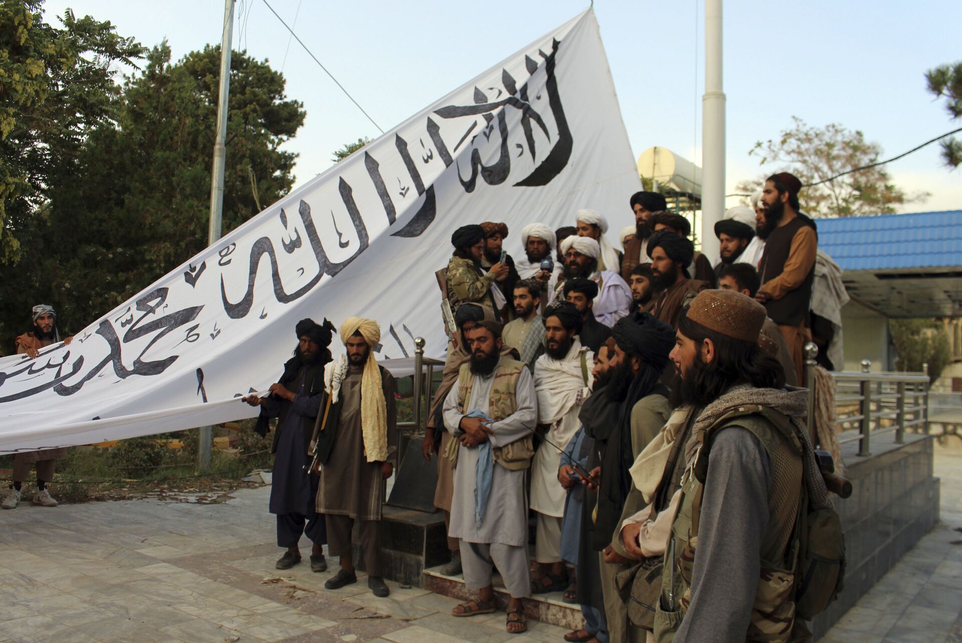 Các chiến binh Taliban chụp ảnh trong khi giương cao lá cờ Các chiến binh Taliban giương cao lá cờ của họ tại nhà thống đốc tỉnh Ghazni, ở Ghazni, đông nam, Afghanistan, Chủ nhật, ngày 15 tháng 8 năm 2021. - Sputnik Việt Nam, 1920, 05.10.2021