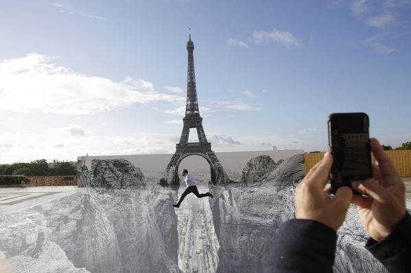 Người đàn ông tạo dáng trên tác phẩm khổng lồ của nghệ sĩ Pháp JR, đặt trong quảng trường Trocadero trước tháp Eiffel ở Paris - Sputnik Việt Nam