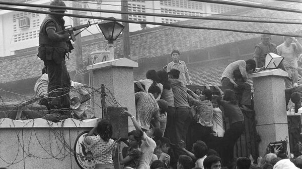 People clamber into the US embassy compound during the fall of Saigon in 1975 - Sputnik Việt Nam
