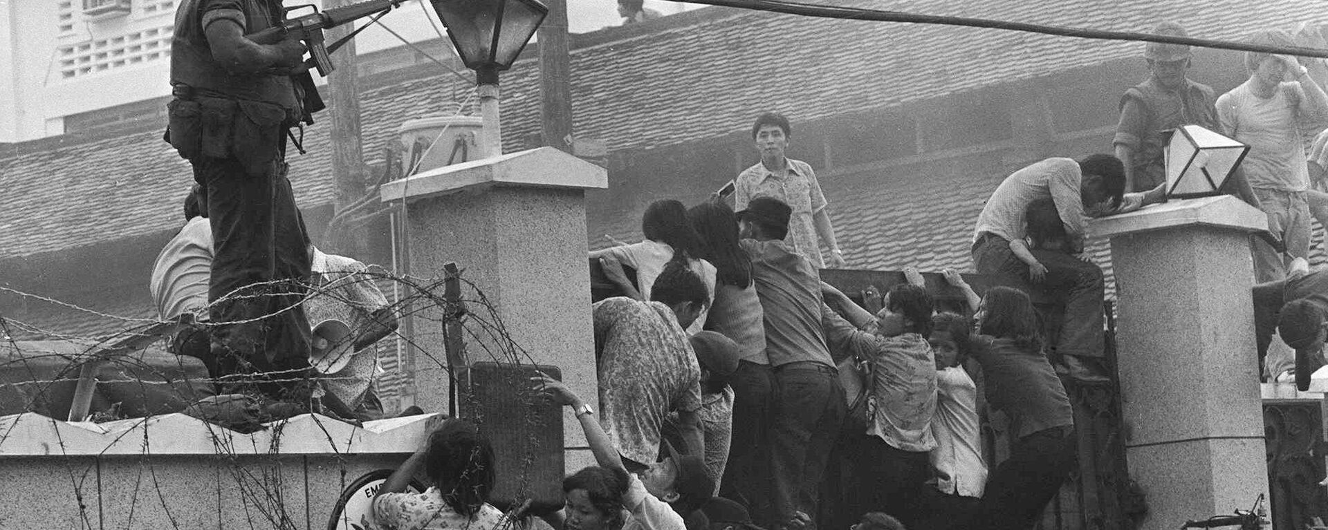 People clamber into the US embassy compound during the fall of Saigon in 1975 - Sputnik Việt Nam, 1920, 21.08.2021