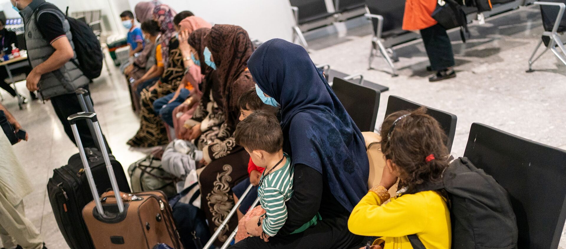 Những người tị nạn từ Afghanistan chờ được xử lý sau khi đáp chuyến bay sơ tán tại sân bay Heathrow, ở London, Anh ngày 26 tháng 8 năm 2021 - Sputnik Việt Nam, 1920, 02.09.2021