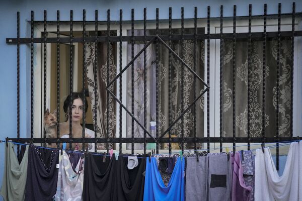 Người phụ nữ sau  cửa sổ xem buổi biểu diễn ngoài trời ở Bucharest, Romania - Sputnik Việt Nam