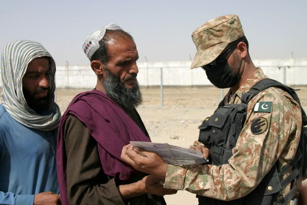 Người lính Pakistan kiểm tra giấy tờ của những người đến từ Afghanistan tại trạm kiểm soát Cổng Tình bạn ở Chaman, thị trấn biên giới Pakistan-Afghanistan, Pakistan - Sputnik Việt Nam