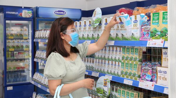 Khách hàng đứng bên quầy bán sản phẩm của Công ty Sữa Việt Nam Vinamilk trong siêu thị - Sputnik Việt Nam