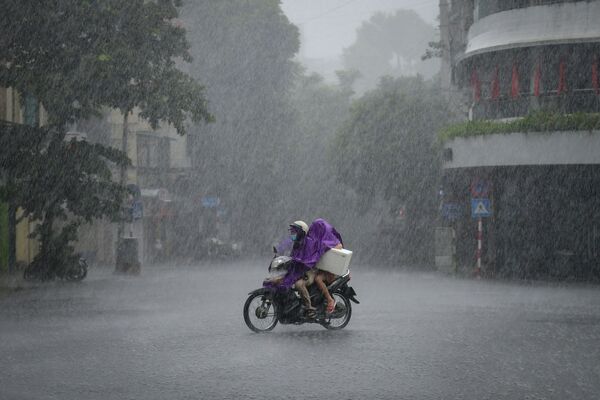 Người dân đi xe tay ga trong cơn mưa tầm tã ở Hà Nội, Việt Nam  - Sputnik Việt Nam