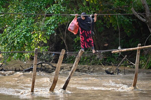 Người phụ nữ vượt qua cây cầu bị lũ phá hủy ở Nam Sulawesi, Indonesia - Sputnik Việt Nam