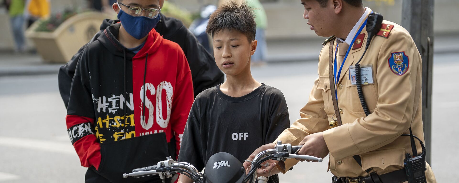 Cảnh sát Việt Nam chặn một cậu bé điều khiển xe máy vì vi phạm luật lệ giao thông trên phố cổ Hà Nội, Việt Nam. - Sputnik Việt Nam, 1920, 23.12.2022
