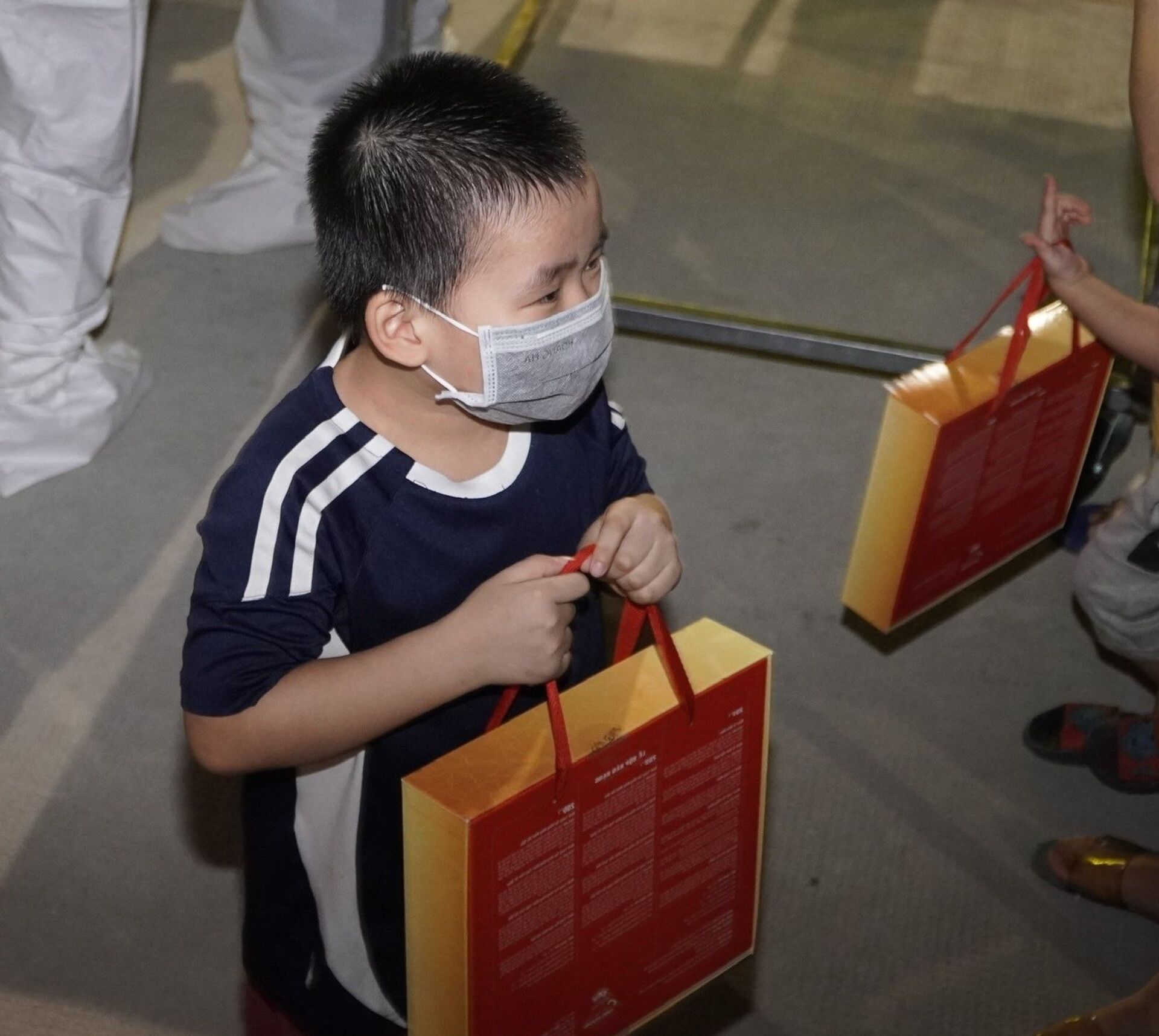 Một trẻ em tại Khu điều trị Bệnh viện dã chiến Thới Hòa, thị xã Bến Cát, tỉnh Bình Dương được tặng quà bánh Trung thu - Sputnik Việt Nam, 1920, 05.10.2021