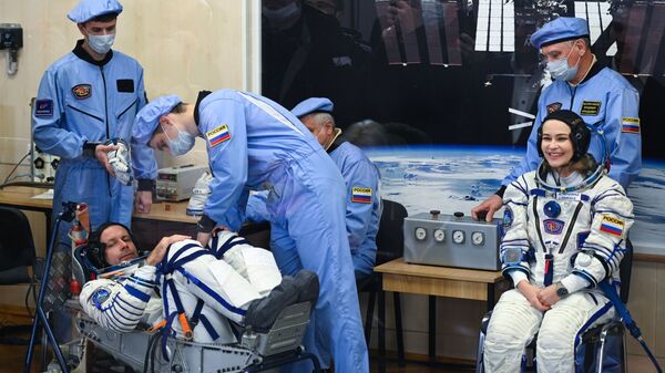 Nữ diễn viên Yulia Peresild và đạo diễn Klim Shipenko mặc bộ đồ vũ trụ trước khi phóng tàu vũ trụ Soyuz MS-19 tại sân bay vũ trụ Baikonur - Sputnik Việt Nam