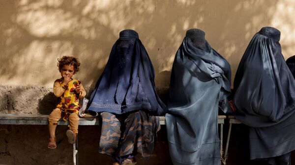 Cô bé bên cạnh những người phụ nữ trong quán rượu bên ngoài bệnh viện ở Kabul - Sputnik Việt Nam
