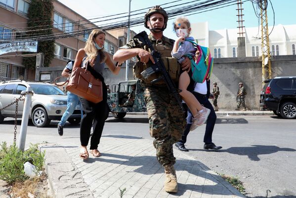 Người lính cõng em học sinh khi các thường dân chạy trốn khỏi vụ xả súng ở Beirut, Lebanon - Sputnik Việt Nam