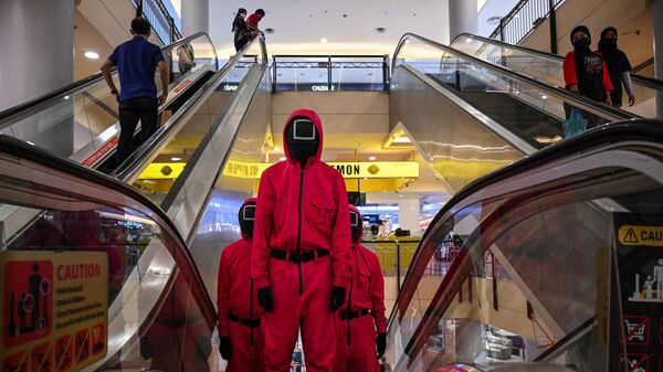 Những người hóa trang trong trang phục nhân vật của bộ phim truyền hình Netflix Trò chơi con mực tại trung tâm mua sắm Kuala Lumpur, Malaysia  - Sputnik Việt Nam