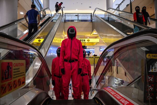 Những người hóa trang trong trang phục nhân vật của bộ phim truyền hình Netflix &quot;Trò chơi con mực&quot; tại trung tâm mua sắm Kuala Lumpur, Malaysia - Sputnik Việt Nam
