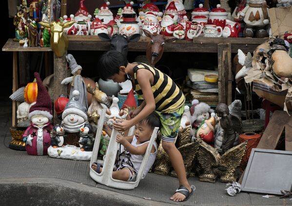Bọn trẻ chơi đùa bên những món đồ trang trí Giáng sinh bày bán trên con phố ở Manila, Philippines - Sputnik Việt Nam