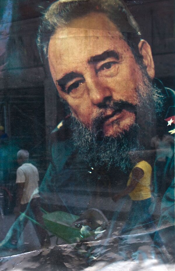 Chân dung của nhà lãnh đạo Cuba Fidel Castro được phản chiếu qua cửa sổ cửa hàng ở Havana vào ngày 12 tháng 8 năm 2009 - Sputnik Việt Nam