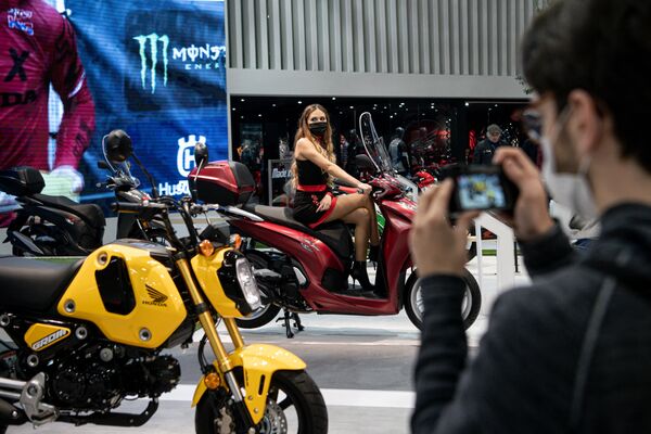 Một người đàn ông chụp ảnh người mẫu trên chiếc xe máy Honda tại triển lãm ở Milan - Sputnik Việt Nam