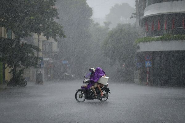 Người dân đi xe tay ga qua cơn mưa tầm tã ở Hà Nội - Sputnik Việt Nam