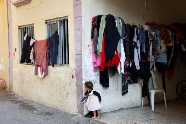 Đứa trẻ nhìn từ góc tòa nhà ở khu vực Beirut&#x27;s Karantina, Lebanon - Sputnik Việt Nam