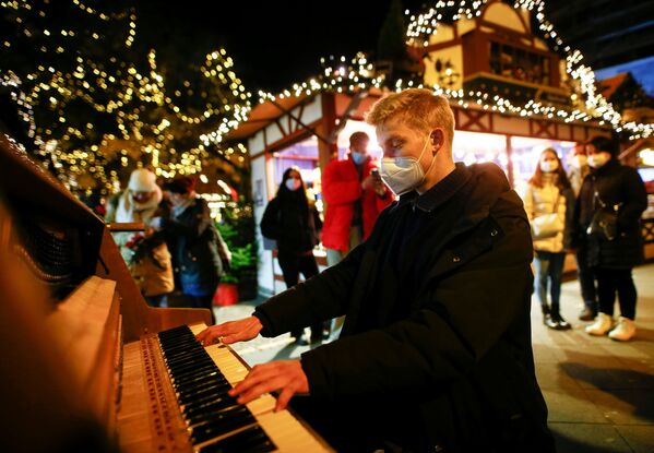 Một nhạc sĩ chơi piano tại chợ Giáng sinh ở Cologne - Sputnik Việt Nam
