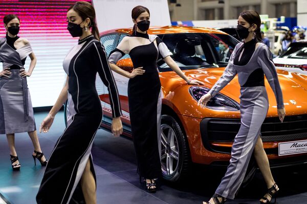 Những người mẫu đi qua chiếc siêu xe Porsche Macan tại triển lãm Thai International Motor Expo 2021 ở Bangkok - Sputnik Việt Nam