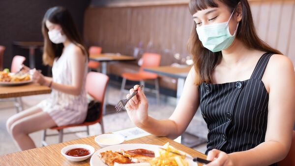 Cô gái châu Á đeo mặt nạ ở bàn riêng trong nhà hàng - Sputnik Việt Nam