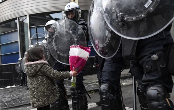 Cô bé tặng hoa cho cảnh sát đặc nhiệm trong cuộc biểu tình phản đối các biện pháp chống coronavirus ở Brussels, Bỉ - Sputnik Việt Nam