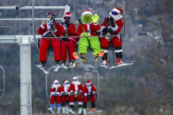Các thành viên tham gia cuộc đua trượt tuyết thường niên Santa Claus tại khu nghỉ dưỡng vùng núi Sunday River (Dòng sông Chủ nhật) ở Newry thuộc bang Maine, Hoa Kỳ - Sputnik Việt Nam