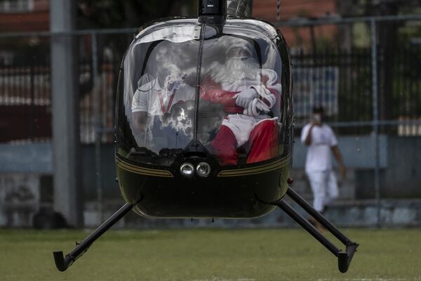 Người đàn ông hóa trang thành Ông già Noel đi trực thăng đến đón Giáng sinh ở Rio de Janeiro, Brazil - Sputnik Việt Nam