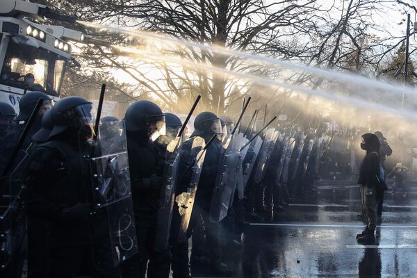 Những người phản đối tiêm vaccine trước cảnh sát sử dụng vòi rồng trong cuộc biểu tình chống các biện pháp của chính phủ nhằm ngăn chặn sự lây lan COVID-19 ở Luxembourg - Sputnik Việt Nam