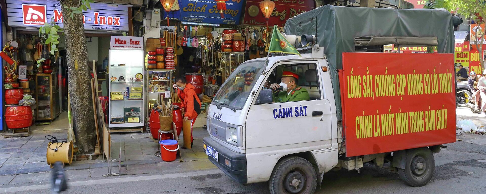 Lực lượng chức năng nhắc nhở việc đóng cửa các cửa hàng kinh doanh không thiết yếu trên phố Hàng Nón (phường Hàng Gai). - Sputnik Việt Nam, 1920, 19.12.2021