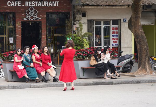 Những người phụ nữ vui vẻ chụp ảnh kỷ niệm trong trang phục mũ ông già Noel - Sputnik Việt Nam