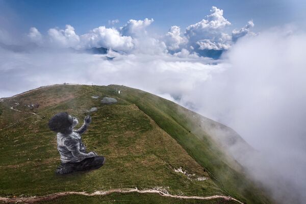 Bức tranh nghệ thuật khổng lồ theo phong cách land- art của nghệ sĩ Pháp Guillaume Legros, mô tả cậu bé rẽ đám mây trên đỉnh núi Moleson - Sputnik Việt Nam