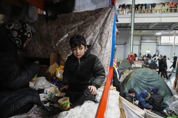 Người tị nạn ăn đồăn nhanh tại Trung tâm lưu trú ở trung tâm vận tải và hậu cần «Bruzgi» gần biên giới Belarus-Ba Lan - Sputnik Việt Nam