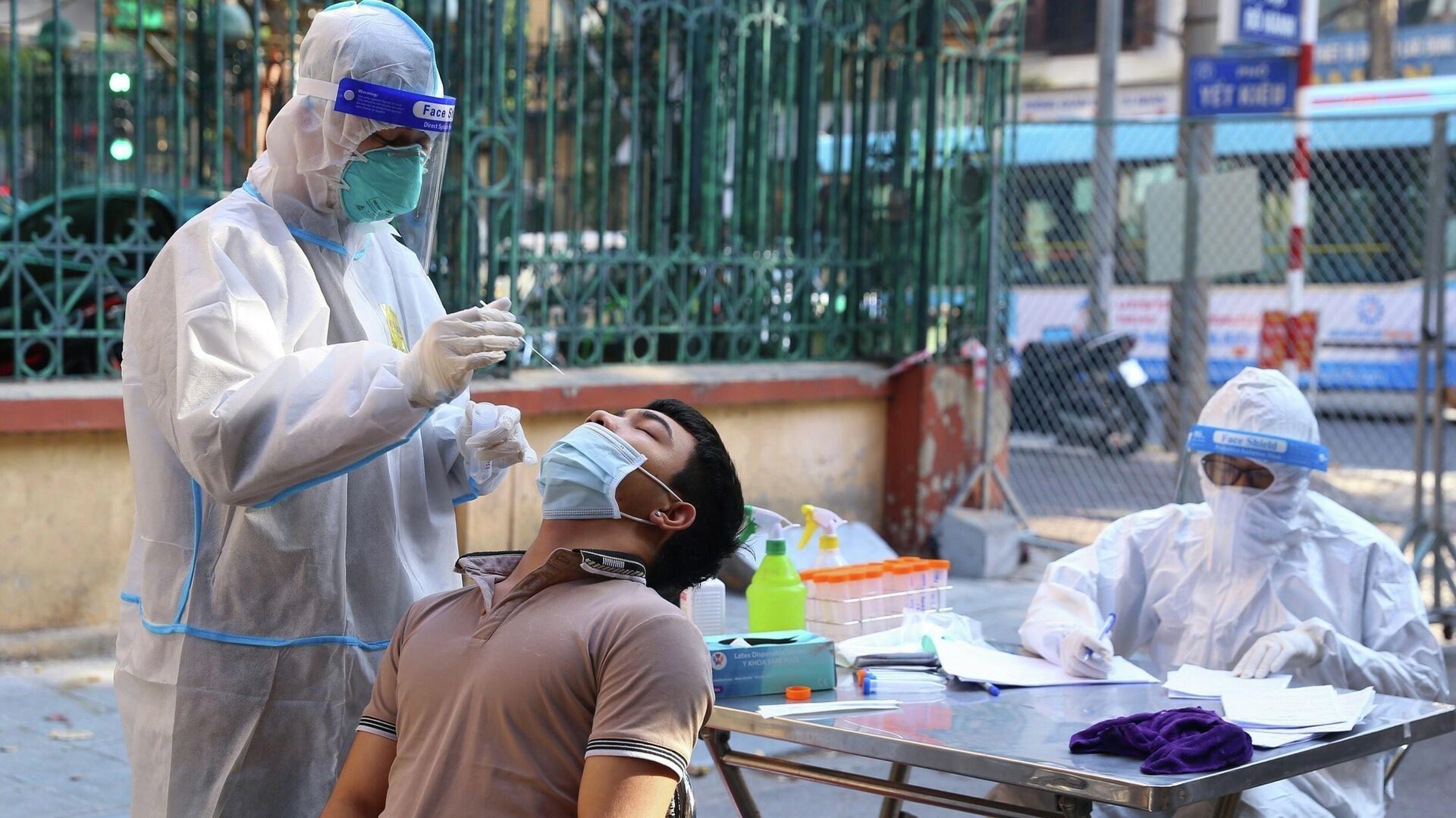 Nhân viên y tế lấy mẫu xét nghiệm sàng lọc COVID-19 cho người dân trong khu vực bị phong tỏa thuộc phường Nguyễn Du (Hà Nội) - Sputnik Việt Nam, 1920, 01.01.2022