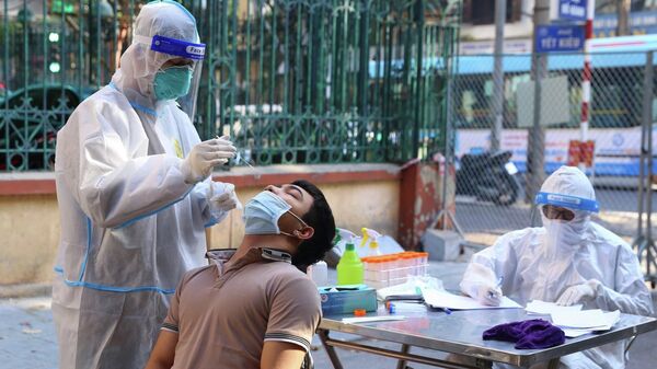 Nhân viên y tế lấy mẫu xét nghiệm sàng lọc COVID-19 cho người dân trong khu vực bị phong tỏa thuộc phường Nguyễn Du (Hà Nội) - Sputnik Việt Nam