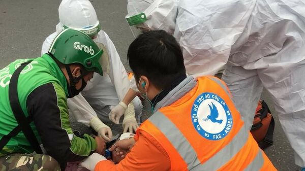 Anh Việt cùng các nhân viên y tế sơ cứu người bị tai nạn tại hiện trường - Sputnik Việt Nam