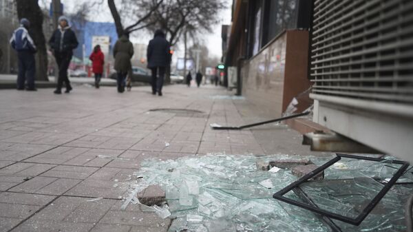 Người dân Almaty đi ngang qua cửa hàng có những ô cửa kính bị vỡ - Sputnik Việt Nam