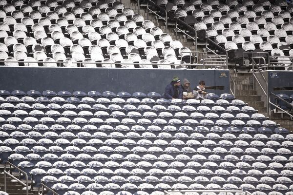 Ba người hâm mộ ngồi cùng nhau giữa những chiếc ghế phủ đầy tuyết trước một trận bóng đá ở Seattle - Sputnik Việt Nam