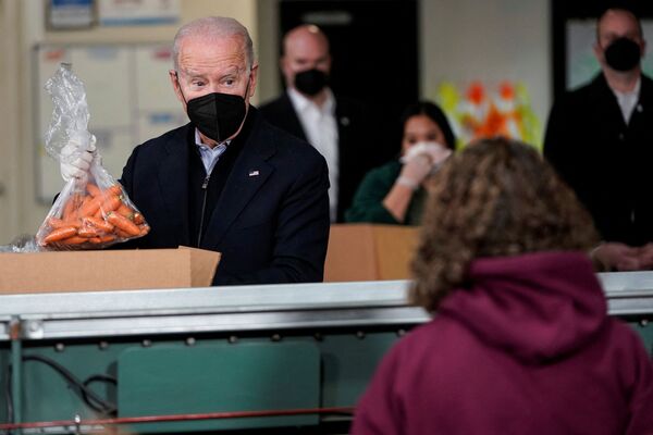Tổng thống Mỹ Joe Biden đặt túi cà rốt vào hộp của tổ chức cứu trợ nạn đói ở Philadelphia - Sputnik Việt Nam