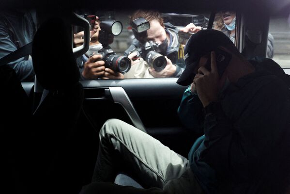 Các nhà báo chụp ảnh người đàn ông không rõ danh tính rời khỏi bãi đậu xe bên ngoài văn phòng nhóm luật sư của tay vợt người Serbia, Novak Djokovic, được cảnh sát hộ tống, Melbourne, Australia - Sputnik Việt Nam