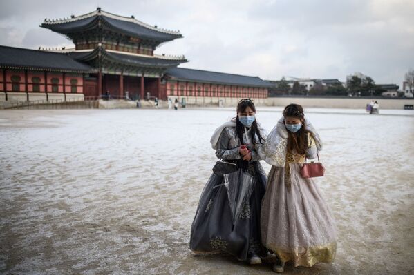 Nữ du khách mặc trang phục hanbok truyền thống đi bộ trong khuôn viên Cung điện Gyeongbokgung sau trận tuyết rơi ở Seoul, Hàn Quốc - Sputnik Việt Nam