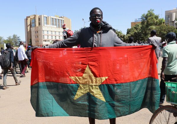 Một người đàn ông cầm quốc kỳ ủng hộ quân đội ở Burkina Faso - Sputnik Việt Nam
