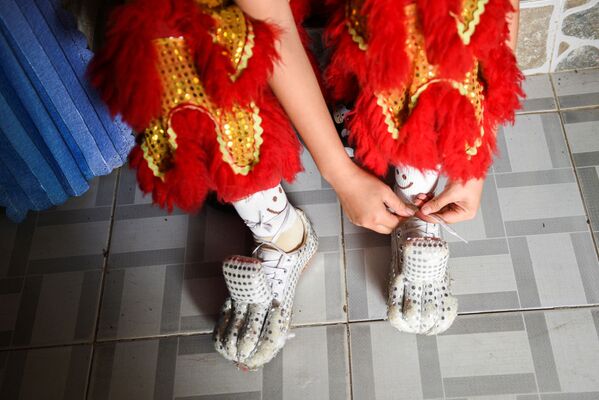 Vũ công Nguyễn Thùy Hương xỏ đôi giày đặc biệt trước buổi tổng duyệt tại Đoàn nghệ thuật múa lân sư rồng Tú Anh Đường ở Cần Thơ, Việt Nam - Sputnik Việt Nam