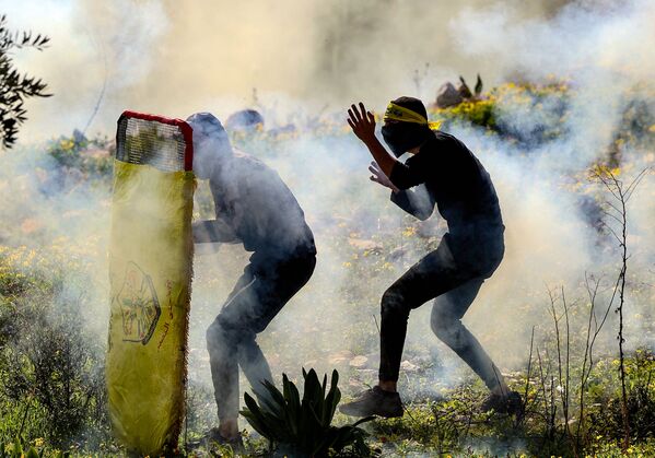 Thanh niên Palestine nấp sau tấm lá chắn tạm bợ trong cuộc đụng độ với lực lượng an ninh Israel - Sputnik Việt Nam