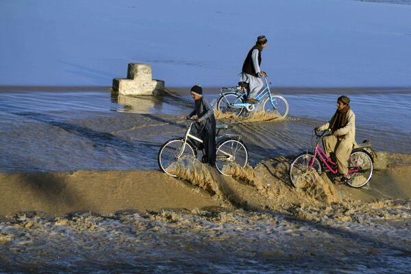Bé trai đạp xe trong nước lũ ở Kandahar - Sputnik Việt Nam