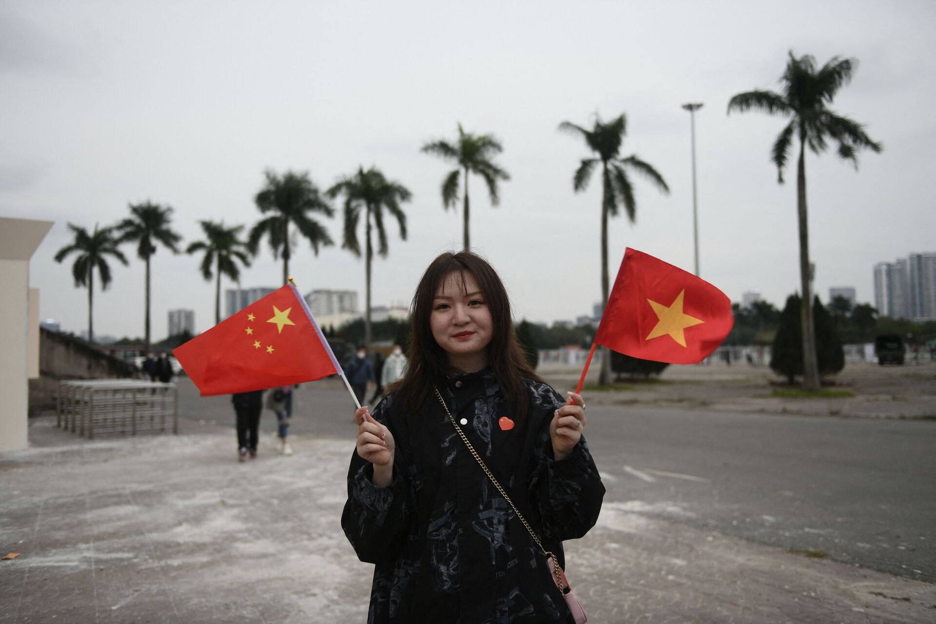 Một cô gái cầm cờ Việt Nam và Trung Quốc trước trận đấu bóng đá vòng loại World Cup 2022 tại Hà Nội - Sputnik Việt Nam, 1920, 01.02.2022